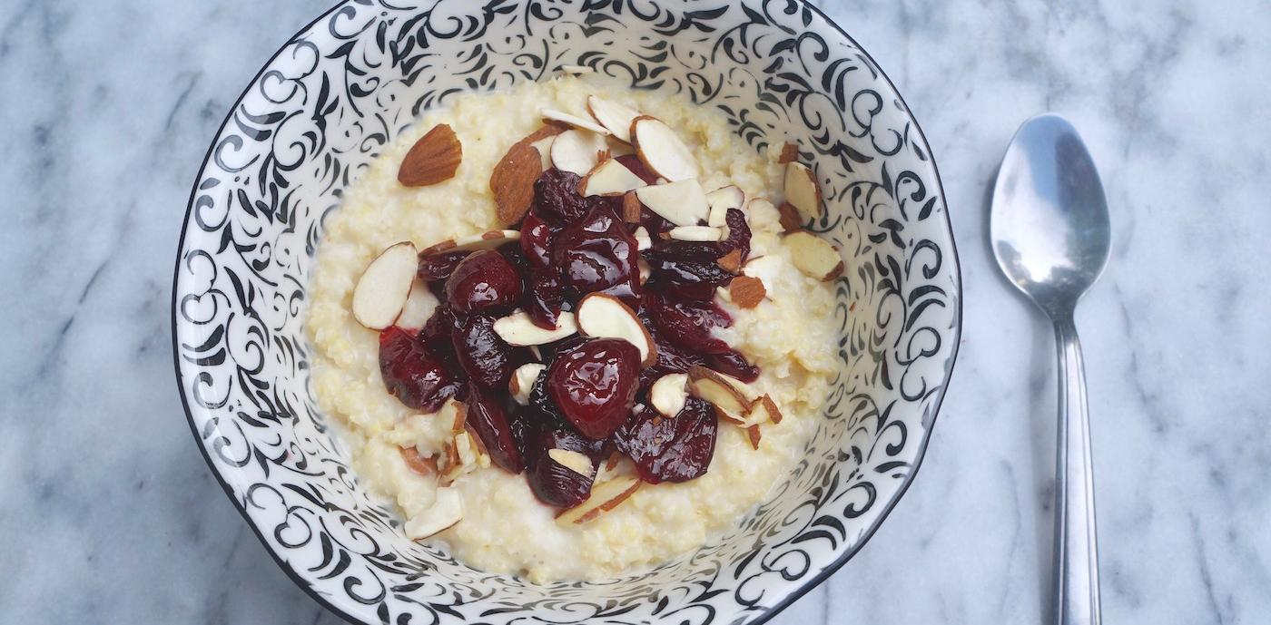 Millet porridge topped with cherry compote and almonds