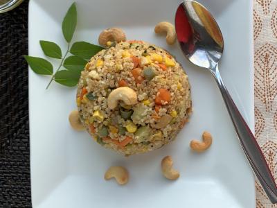 a rounded scoop of a wheat and vegetable dish on a white plate