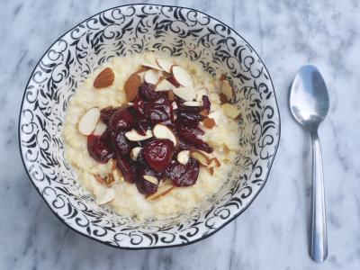Millet porridge topped with cherry compote and almonds