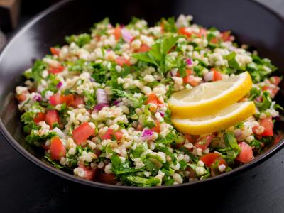 A colorful bowl of tabbouleh with lemon slices