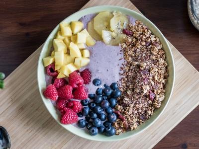 a bowl of acai smoothie topped with granola and colorful fruit