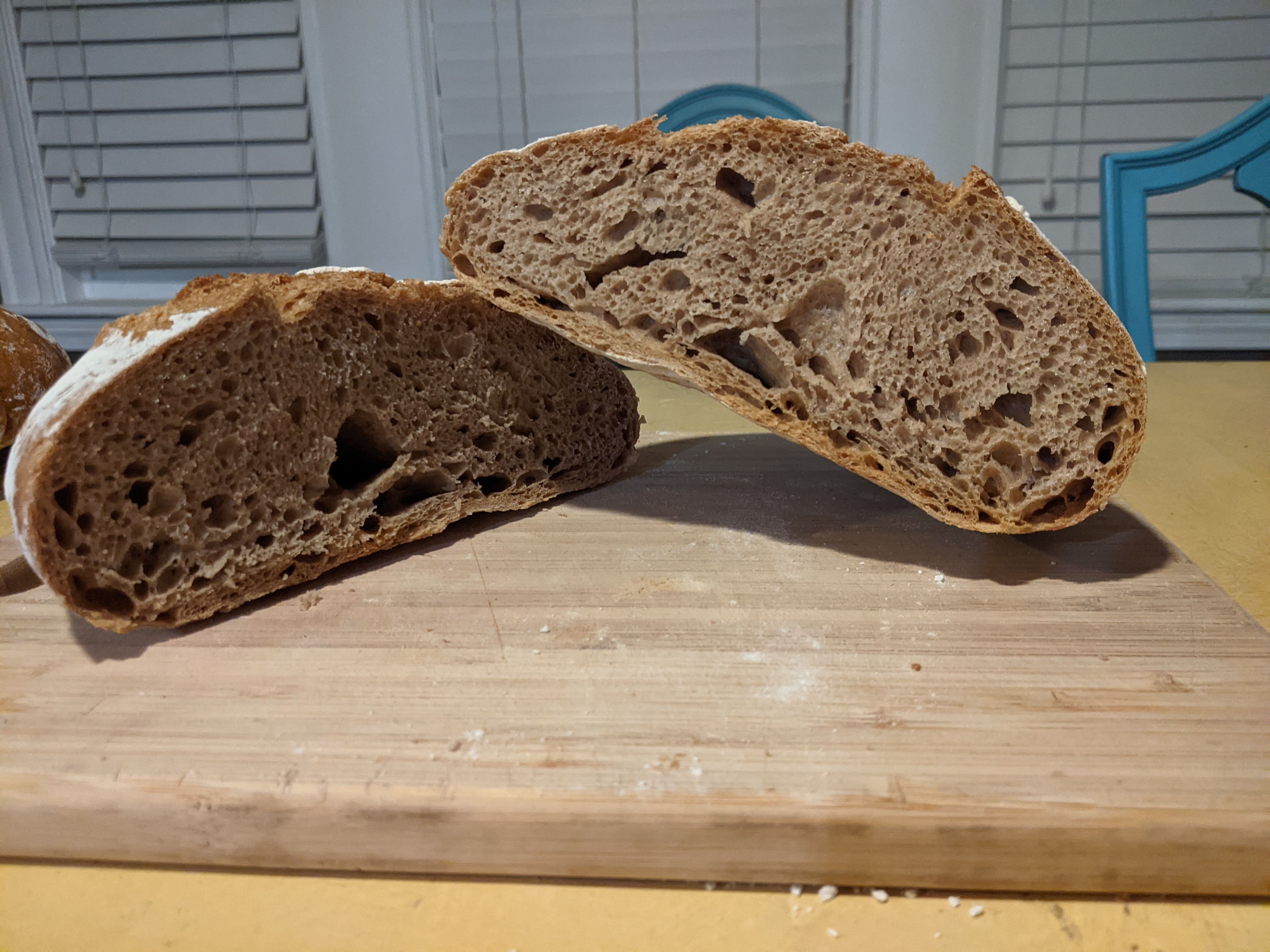 50% whole wheat loaf of bread cut in half on cutting board