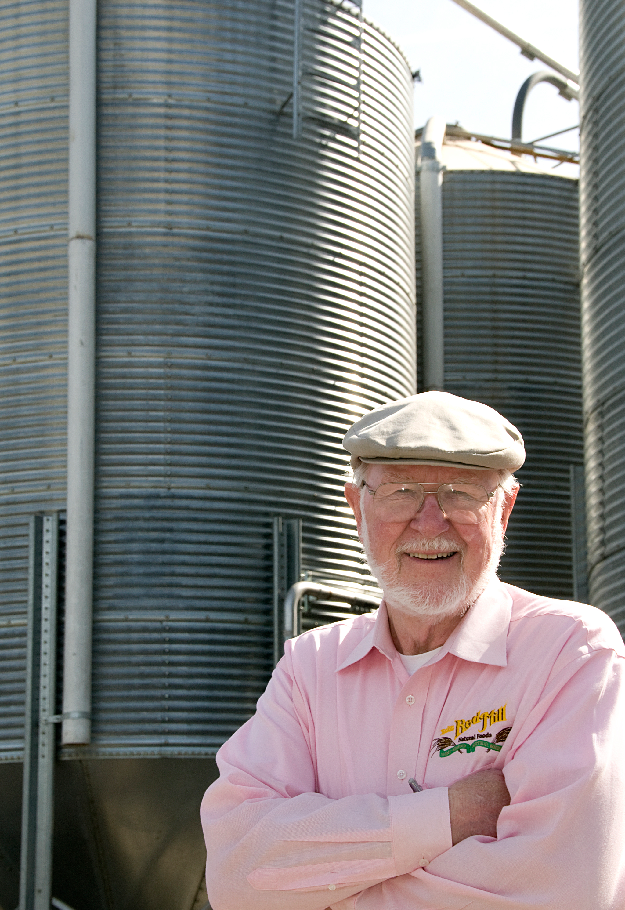 Bob Moore standing in front of large silver grain silos
