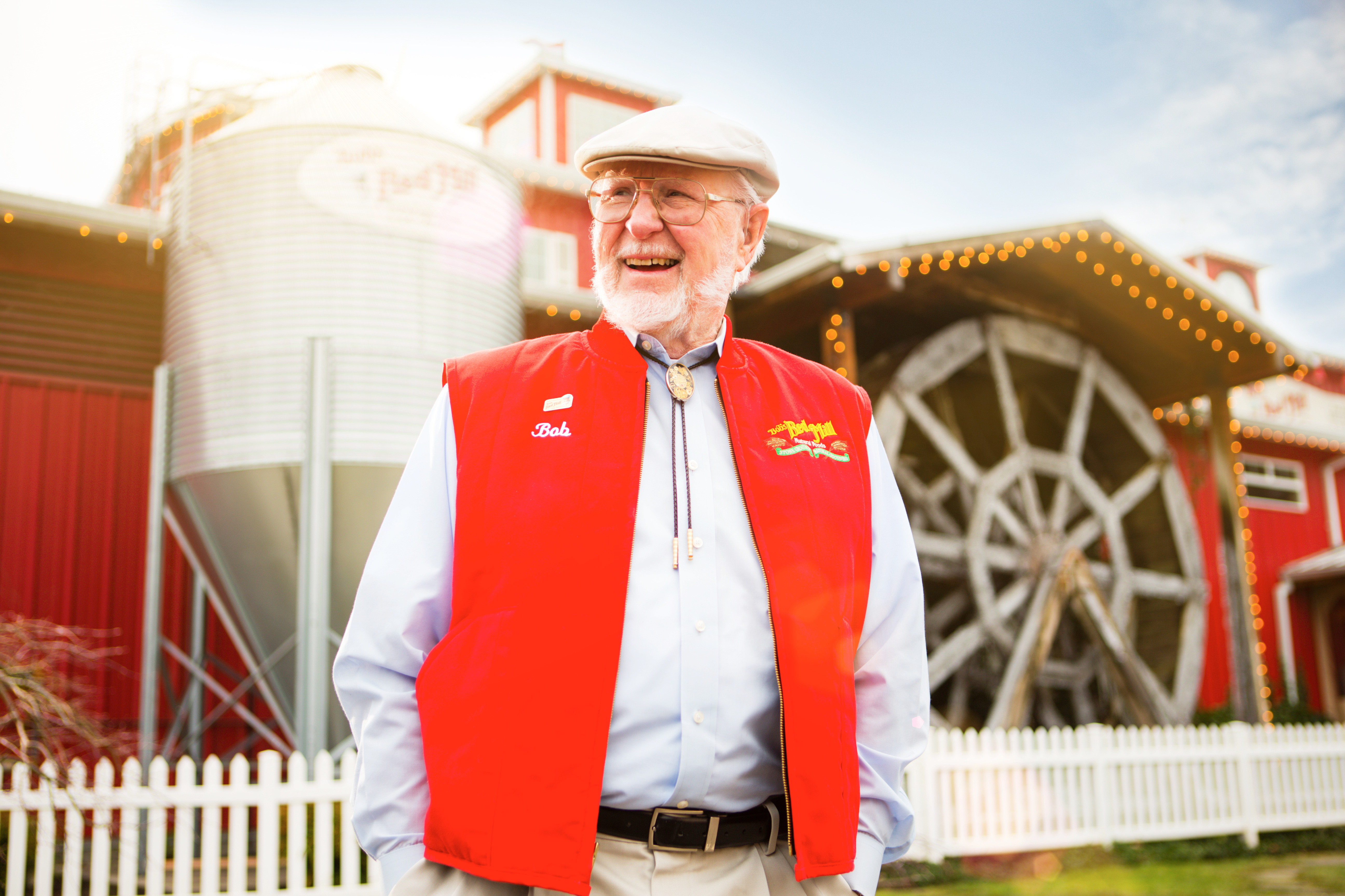 Bob Moore, founder of Bob's Red Mill, standing in front of the iconic red mill
