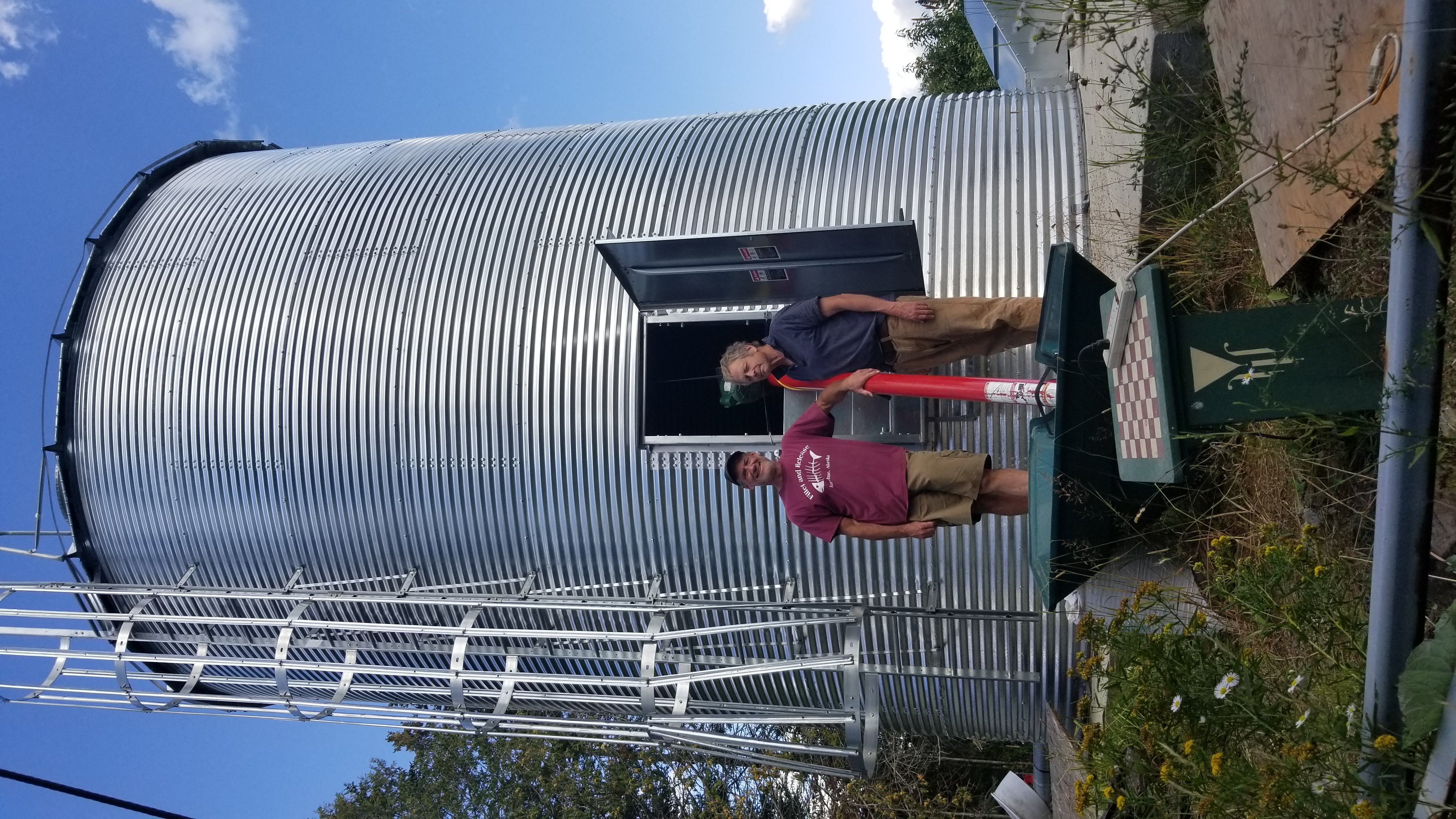 Farmer standing in front of silo of rye grains