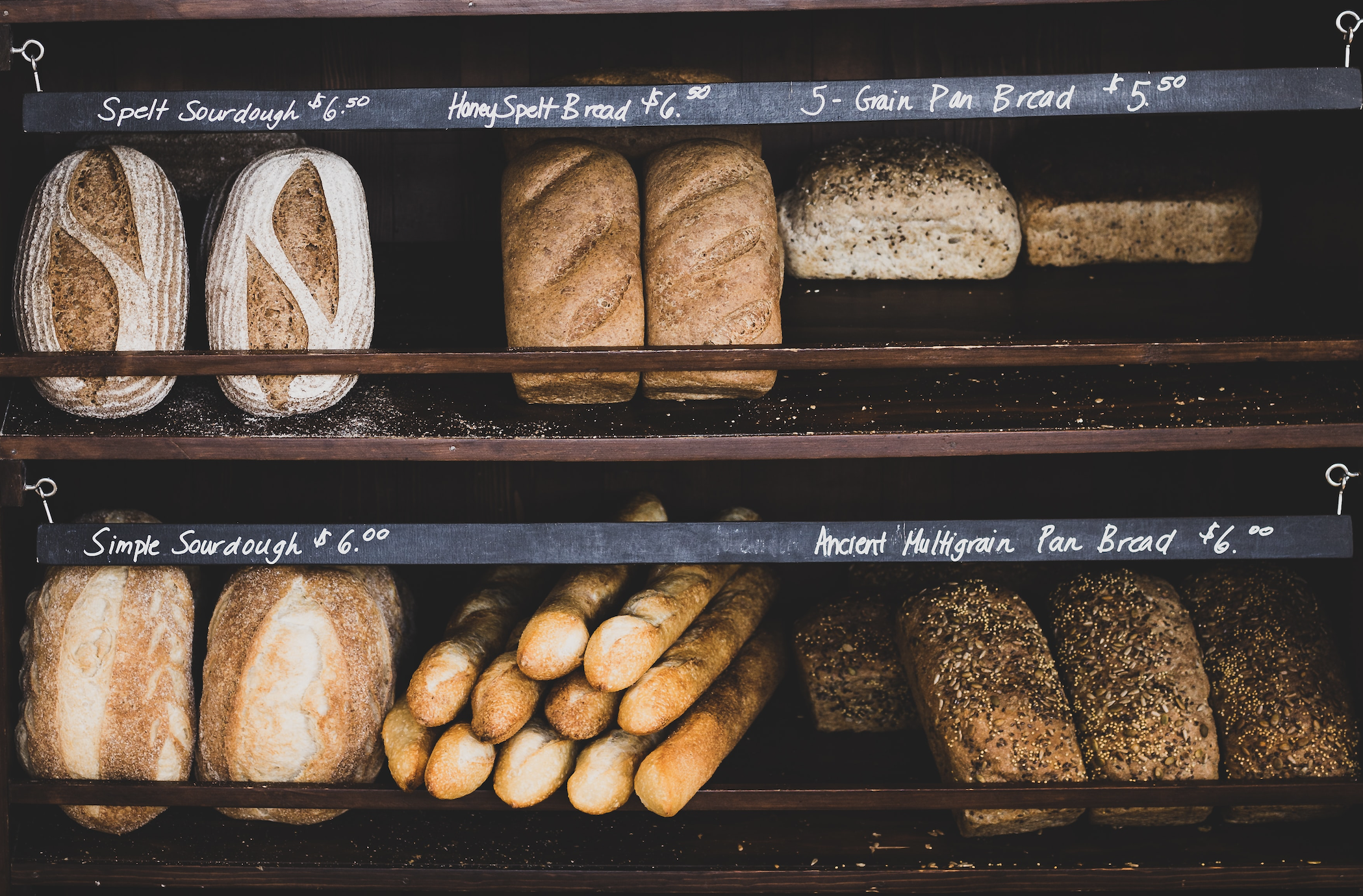 assorted artisan breads displayed on a bakery shelf