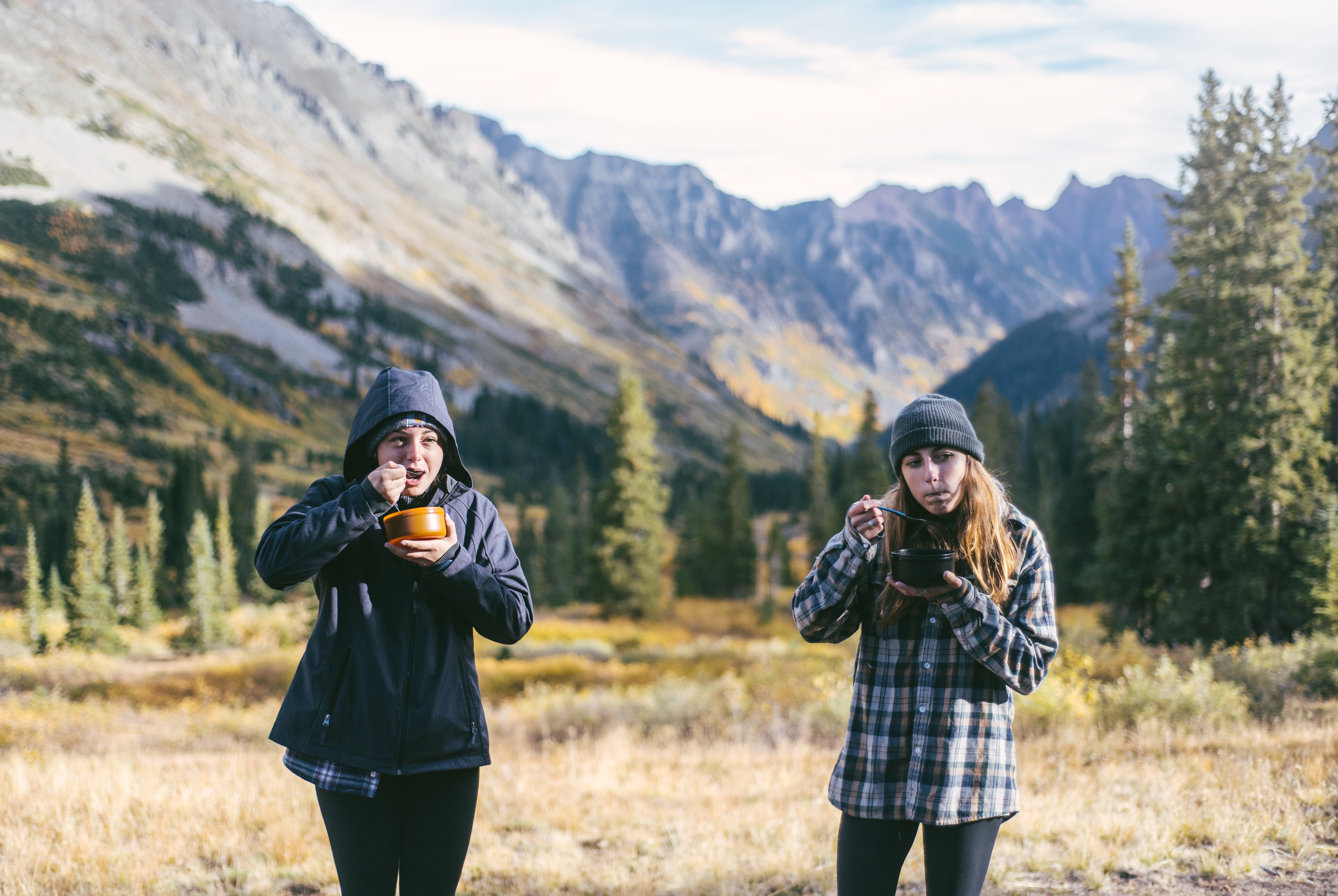 People eating from bowls outside